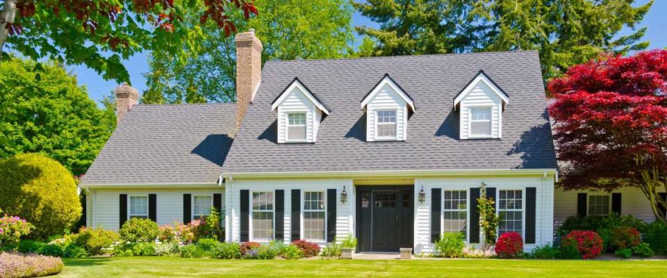 Custom built luxury house with nicely trimmed and landscaped front yard, lawn in a residential neighborhood. Vancouver Canada.