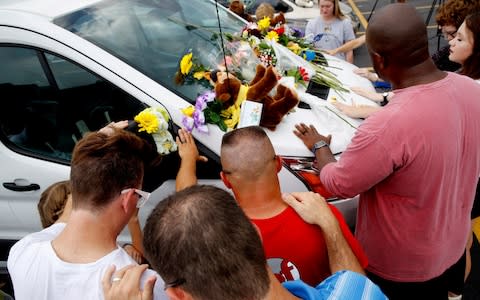 People pray around a van believed to belong to victims of a duck boat accident  - Credit: Charlie Riedel/AP