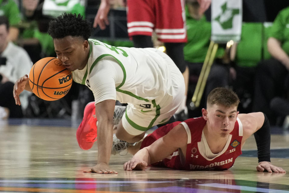 North Texas' Tylor Perry, left, and Wisconsin's Connor Essegian (3) vie for the ball during the second half of an NCAA college basketball game in the semifinals of the NIT, Tuesday, March 28, 2023, in Las Vegas. (AP Photo/John Locher)