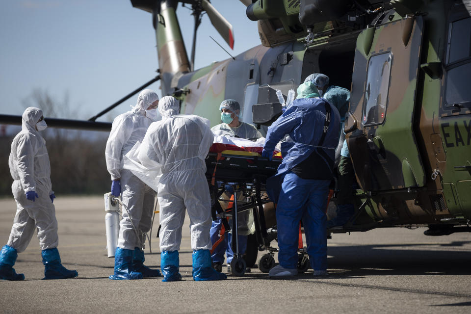 FILE - In this March 30, 2020 file photo, medical staff transfer a patient infected with the coronavirus into a French military helicopter heading to Switzerland. On high-speed trains fitted out like hospitals and military planes, France has moved hundreds of intensive care patients around the country in an exceptional effort to relieve congested hospitals and stay ahead of the fast-moving virus The new coronavirus causes mild or moderate symptoms for most people, but for some, especially older adults and people with existing health problems, it can cause more severe illness or death. (AP Photo/Jean-Francois Badias, File)