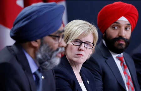 Canada's Public Works Minister Carla Qualtrough (C) and Innovation Minister Navdeep Bains (R) listen to Defence Minister Harjit Sajjan speak during a news conference in Ottawa, Ontario, Canada, December 12, 2017. REUTERS/Chris Wattie