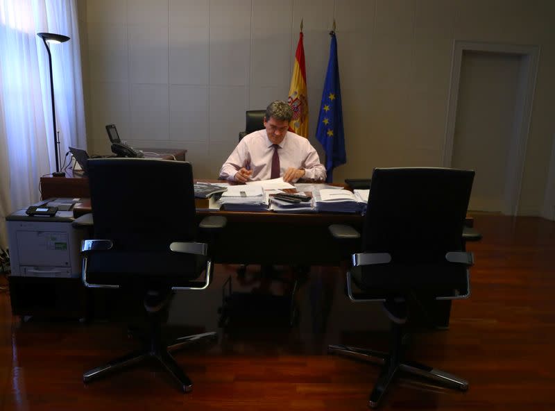 Spain's Social Security Minister, Escriva, works in his office during an interview with Reuters at his ministry in Madrid