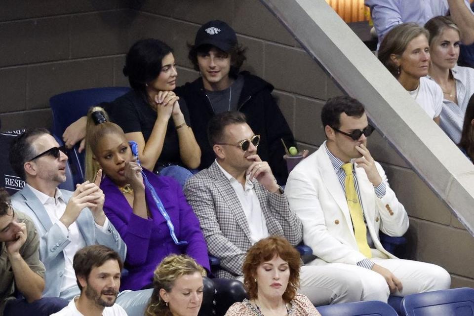 Kylie Jenner, top left, and Timothée Chalamet, top right, intently watch the tournament with other U.S. Open spectators.
