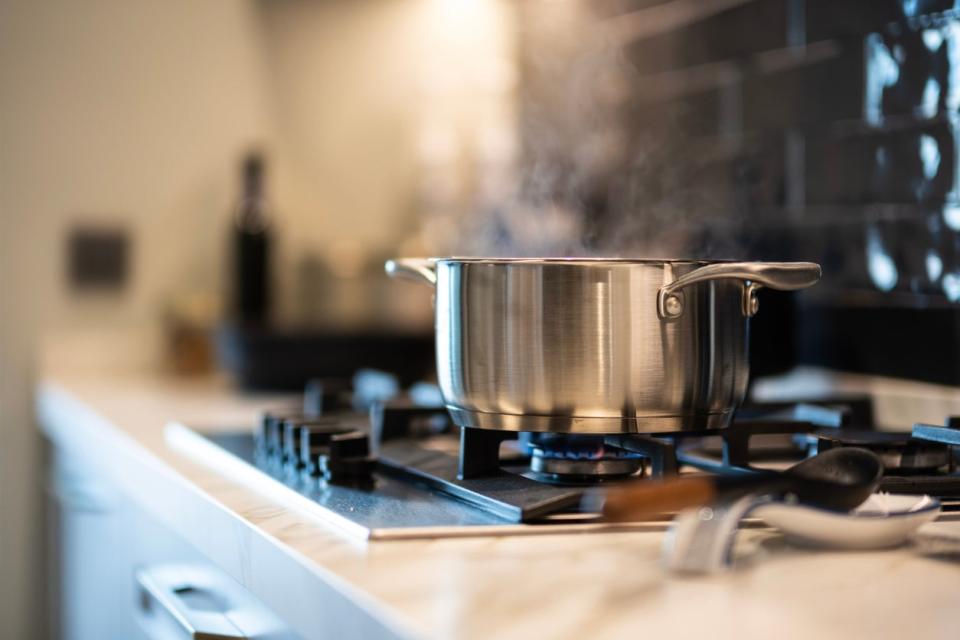 a large metal pot on stove with water boiling inside