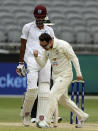 Australia's Travis Head, front, walks past West Indies' Roston Chase while celebrating the wicket of Chase's teammate Alzarri Joseph on the 5th day of their cricket test in Perth, Australia, Sunday, Dec. 4, 2022. (AP Photo/Gary Day)