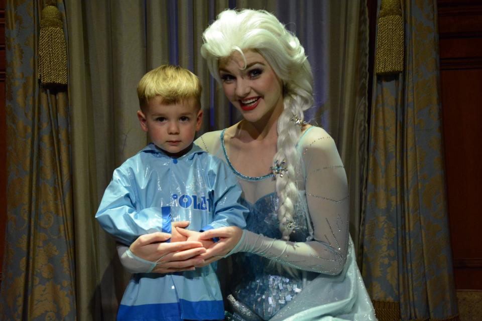 A young child with an actor portraying Disney princess Elsa.