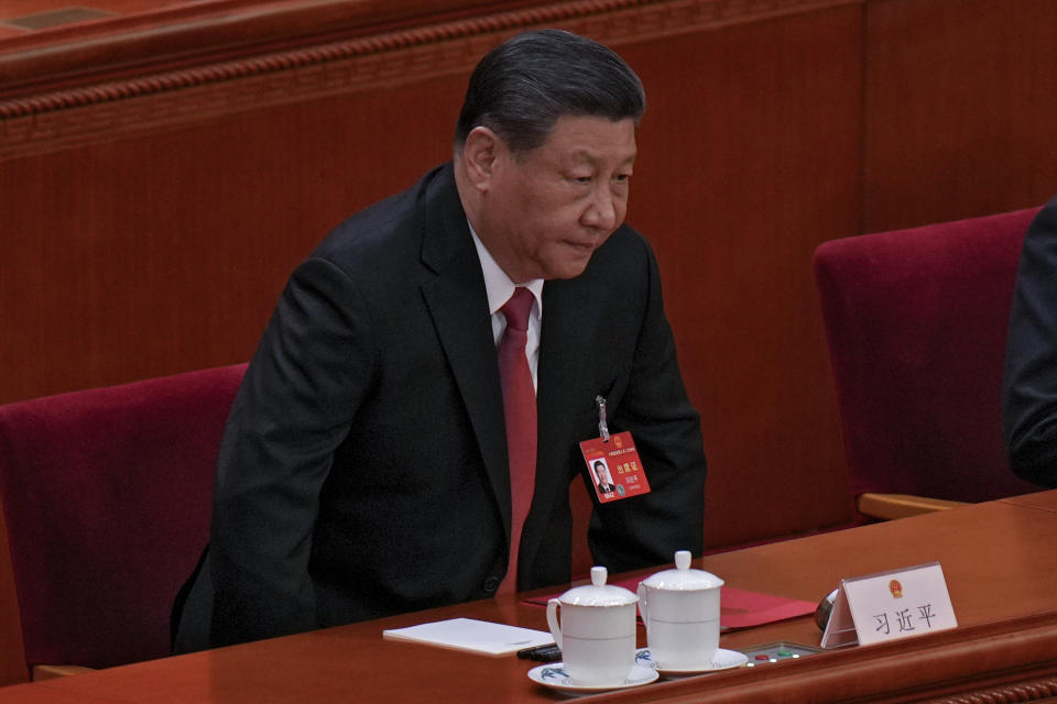 Chinese President Xi Jinping takes a seat as he arrives to the closing session of the National People's Congress (NPC) at the Great Hall of the People in Beijing, Monday, March 11, 2024. (AP Photo/Andy Wong)