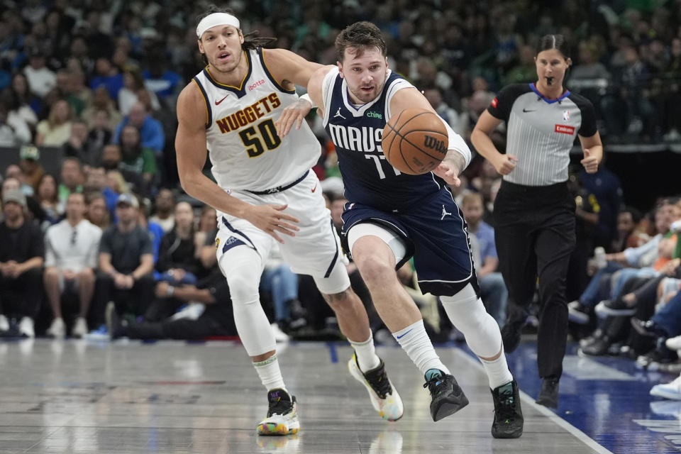 Dallas Mavericks guard Luka Doncic (77) tries to get control of the ball against Denver Nuggets forward Aaron Gordon (50) during the first half of an NBA basketball game in Dallas, Sunday, March 17, 2024. (AP Photo/LM Otero)