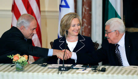 U.S. Secretary of State Hillary Clinton (C) looks on as Israel's Prime Minister Benjamin Netanyahu (L) and President of the Palestinian Authority Mahmoud Abbas shake hands during direct talks aimed at peace in the Middle East, at the State Department in Washington, September 2, 2010. REUTERS/Jason Reed/File Photo