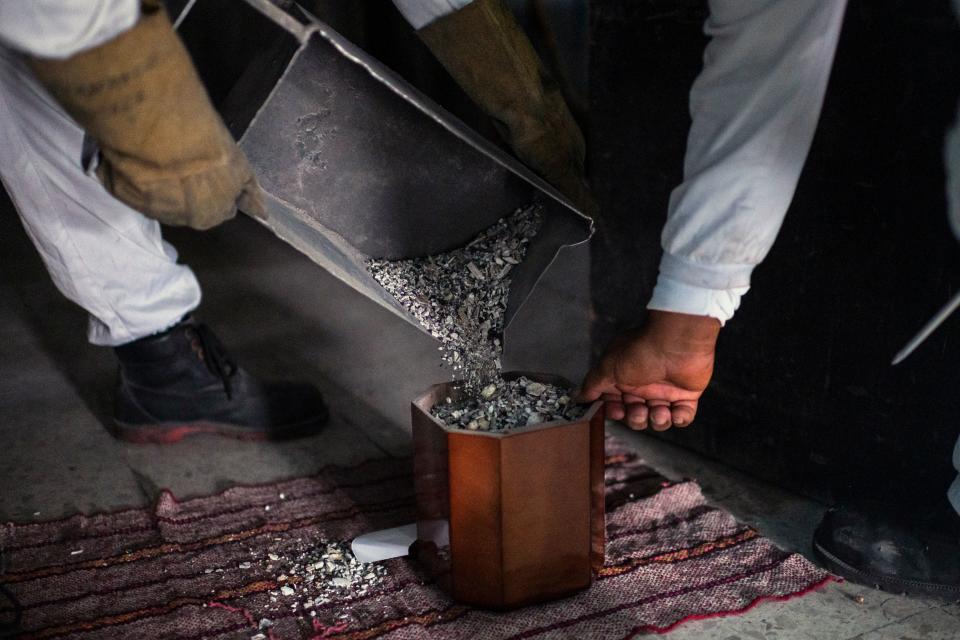 Momento en el que los empleados de Iztapalapa introducen las cenizas de la víctima del coronavirus en una urna funeraria. (Photo by PEDRO PARDO/AFP via Getty Images)