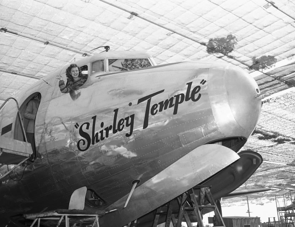 In this Oct. 12, 1944, file photo, Shirley Temple tries out the big four-engine Army transport C-54 which she had just christened with a pat and a kiss, at the Douglas plant, in Santa Monica, Calif. Temple, who died at her home near San Francisco, Monday, Feb. 10, 2014, at 85, sang, danced, sobbed and grinned her way into the hearts of Depression-era moviegoers and remains the ultimate child star decades later. (AP Photo/File)