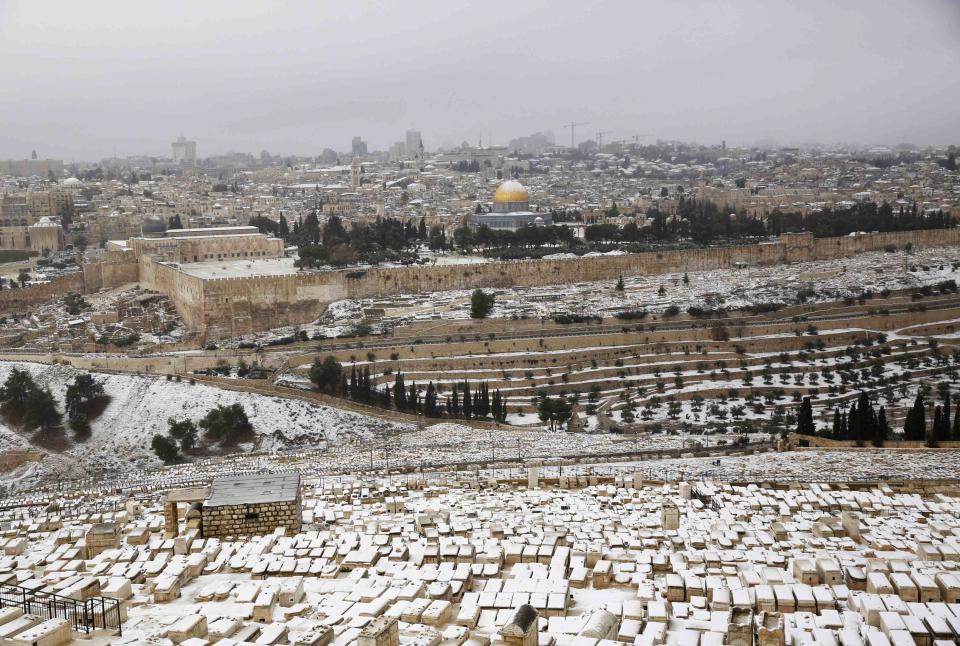 The snow capped Dome of the Rock in Jerusalem's Old City is seen from the Mount of Olives