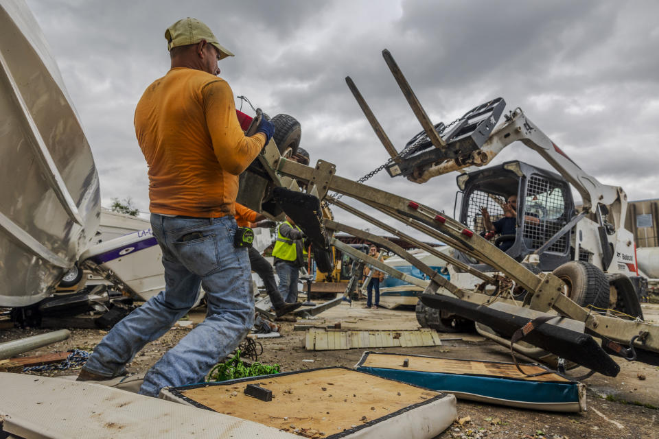 Volunteers and staff of Scotty's Performance Boat & Marine attempt to salvage boats Thursday, April 11, 2024, in Slidell, La., after a tornado hit a day earlier. (Chris Granger/The Times-Picayune/The New Orleans Advocate via AP)