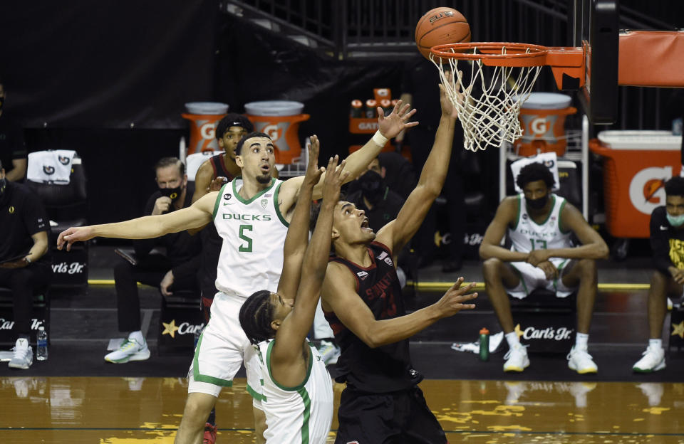 Oregon guard Chris Duarte (5) and Oregon guard LJ Figueroa (12) challenge the shot of Stanford forward Oscar da Silva (13) during the first half of an NCAA college basketball game Saturday, Jan. 2, 2021 in Eugene, Ore. (AP Photo/Andy Nelson)