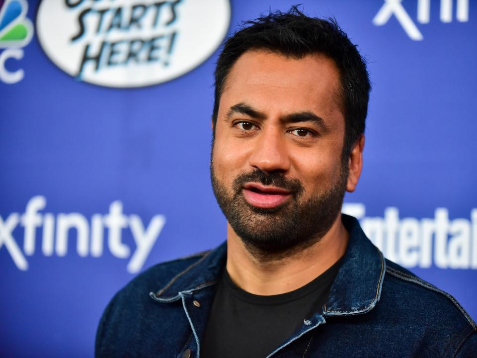 kal penn on a red carpet in a collared shirt