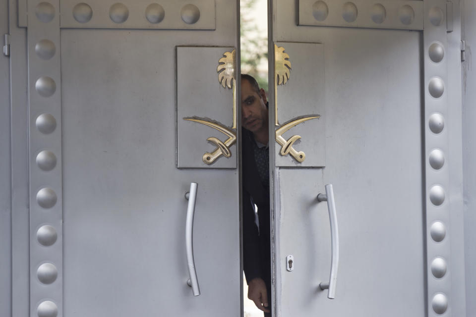 FILE - In this Sunday, Oct. 14, 2018 file photo a security personnel looks out from the entrance of the Saudi Arabia's consulate in Istanbul. (AP Photo/Petros Giannakouris, File)