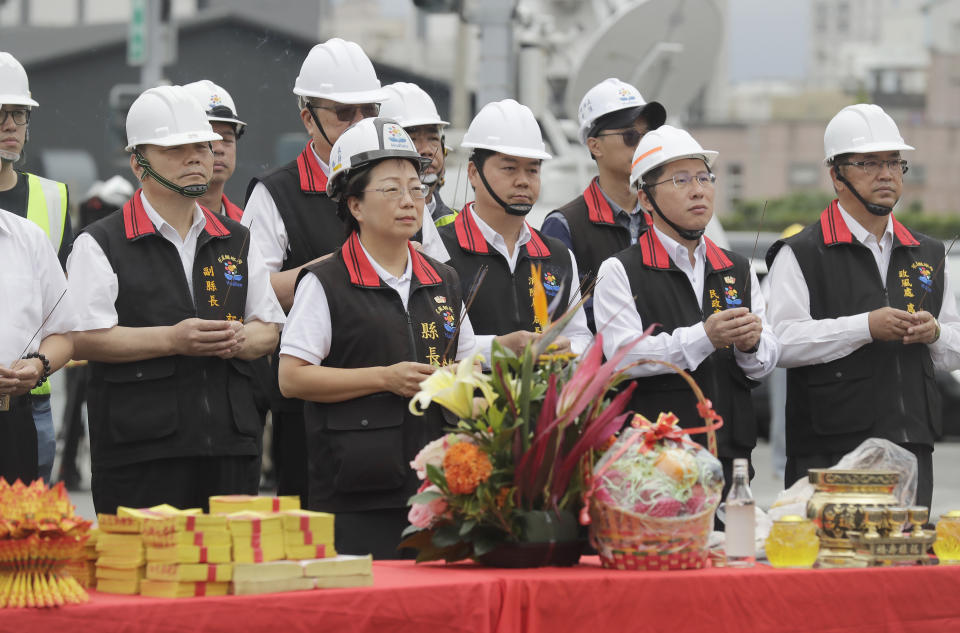 Huilien County magistrate Hsu Chen-wei, center left, with government officials, offer prayers during the demolition ceremony for the partially collapsed building, two days after a powerful earthquake struck the city, in Hualien City, eastern Taiwan, Friday, April 5, 2024. Rescuers searched Thursday for missing people and worked to reach hundreds stranded when Taiwan's strongest earthquake in 25 years sent boulders and mud tumbling down mountainsides, blocking roads. (AP Photo/Chiang Ying-ying)