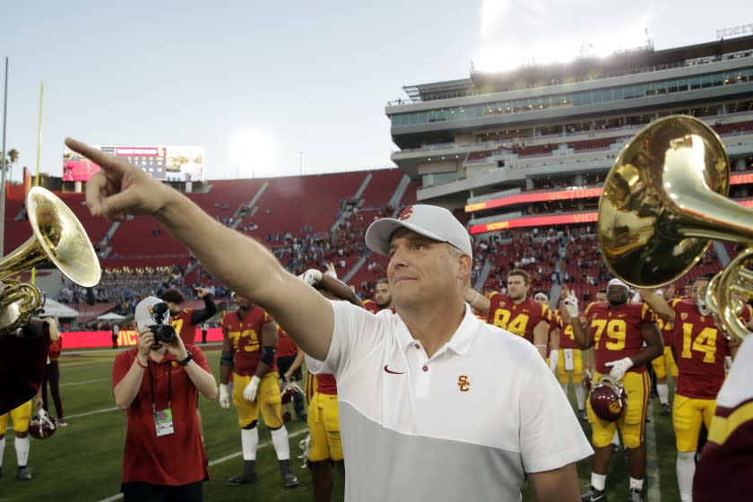 USC coach Clay Helton signals to fans after a 52-35 win over UCLA on Nov. 23, 2019.