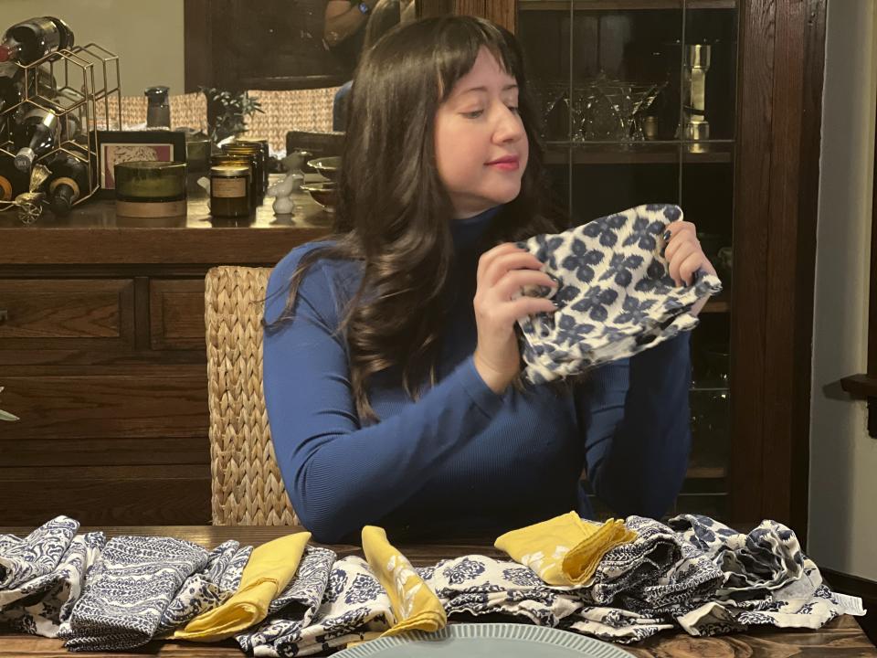 This photo shows Rachel Cooper at home in Chicago with the cloth napkins she purchased to replace paper napkins for daily dining. At the dawn of 2024, also known as New Year's resolution season, there are lots of small, easily achievable ways to lead more climate friendly lives. (Bob Rzadzki via AP).