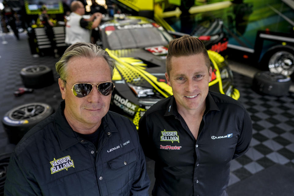 IMSA sports car team Vasser-Sullivan Racing owners, Jimmy Vasser, left, and James Sullivan pose by their Number 14 car at Road Atlanta, Friday, Oct. 13, 2023, in Braselton, Ga. Two years after pulling out of IndyCar to turn its focus toward its growing sports car team, Vasser Sullivan will win its first major championship when Jack Hawksworth and Ben Barnicoat start the IMSA season finale at Road Atlanta on Saturday. The No. 14 Lexus only has to start the race to clinch the GTD Pro title. (AP Photo/Mike Stewart)