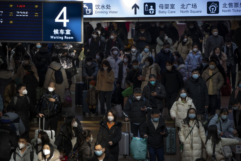 Travelers walk along a concourse at Beijing West Railway Station in Beijing.