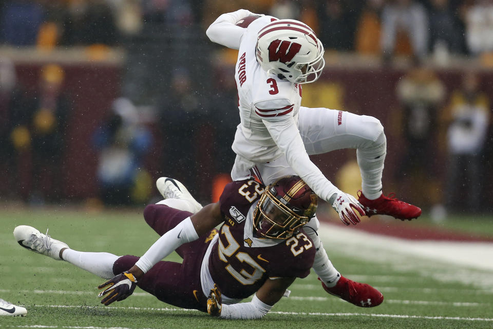 Wisconsin wide receiver Kendric Pryor (3) is knocked down by Minnesota defensive back Jordan Howden (23) during an NCAA college football game Saturday, Nov. 30, 2019, in Minneapolis. (AP Photo/Stacy Bengs)