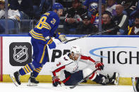 Washington Capitals defenseman Nick Jensen (3) is knocked to the ice by Buffalo Sabres left wing Zemgus Girgensons (28) during the first period of an NHL hockey game Thursday, April 11, 2024, in Buffalo, N.Y. (AP Photo/Jeffrey T. Barnes)