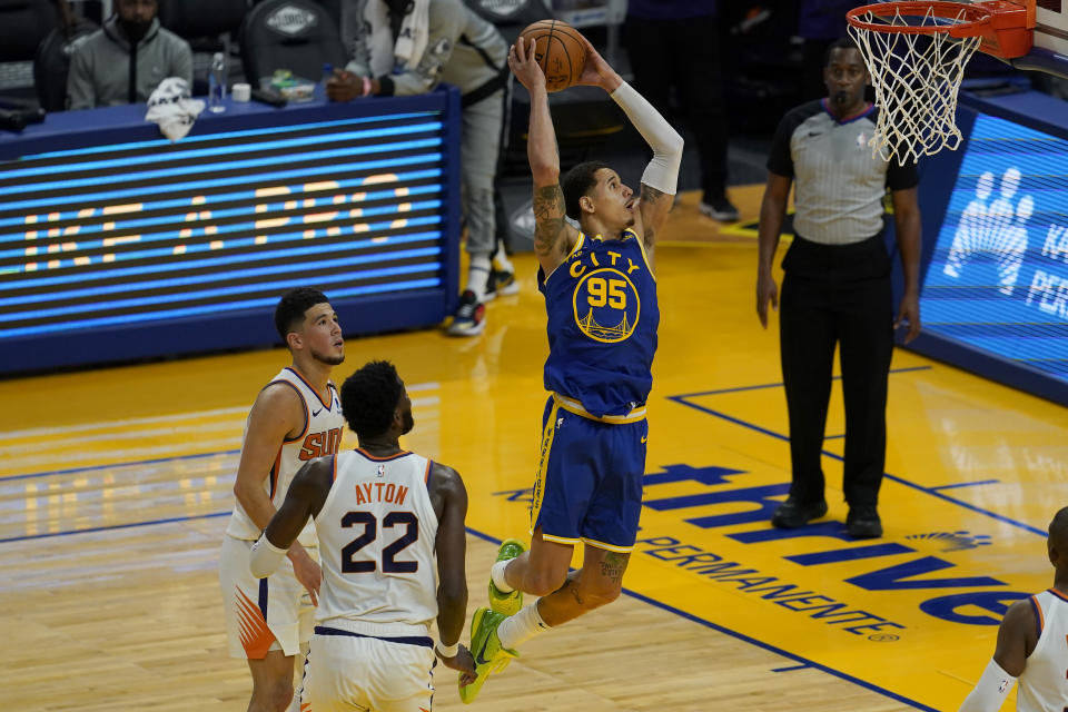 Golden State Warriors forward Juan Toscano-Anderson (95) dunks in front of Phoenix Suns center Deandre Ayton (22) and guard Devin Booker during the first half of an NBA basketball game in San Francisco, Tuesday, May 11, 2021. (AP Photo/Jeff Chiu)