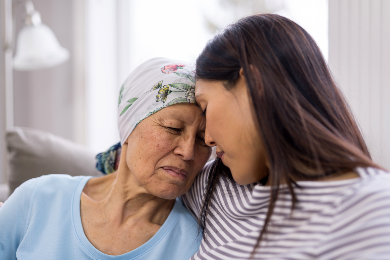 Daughter comforting her mother with cancer