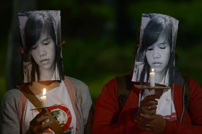 Indonesian migrant workers hold candles during a vigil in support of Filipina drug convict and death row prisoner Mary Jane Veloso outside the presidential palace in Jakarta on April 27, 2015