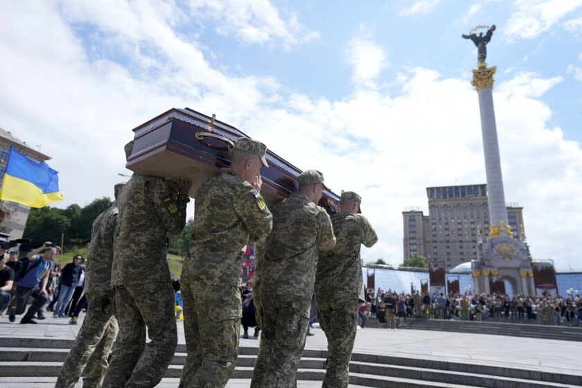 CAPTION CORRECTS FAMILY NAME OF SOLDIER Soldiers carry the coffin of activist and soldier Roman Ratushnyi for a memorial service at Maidan square in Kyiv, Ukraine, Saturday, June 18, 2022. Ratushnyi died in a battle near Izyum, where Russian and Ukrainian troops are fighting for control the area. (AP Photo/Natacha Pisarenko)