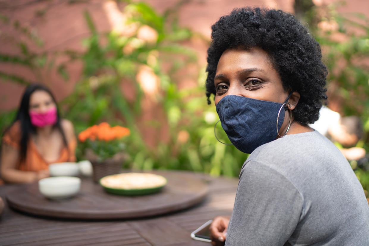 Portrait of woman using protective mask in the backyard