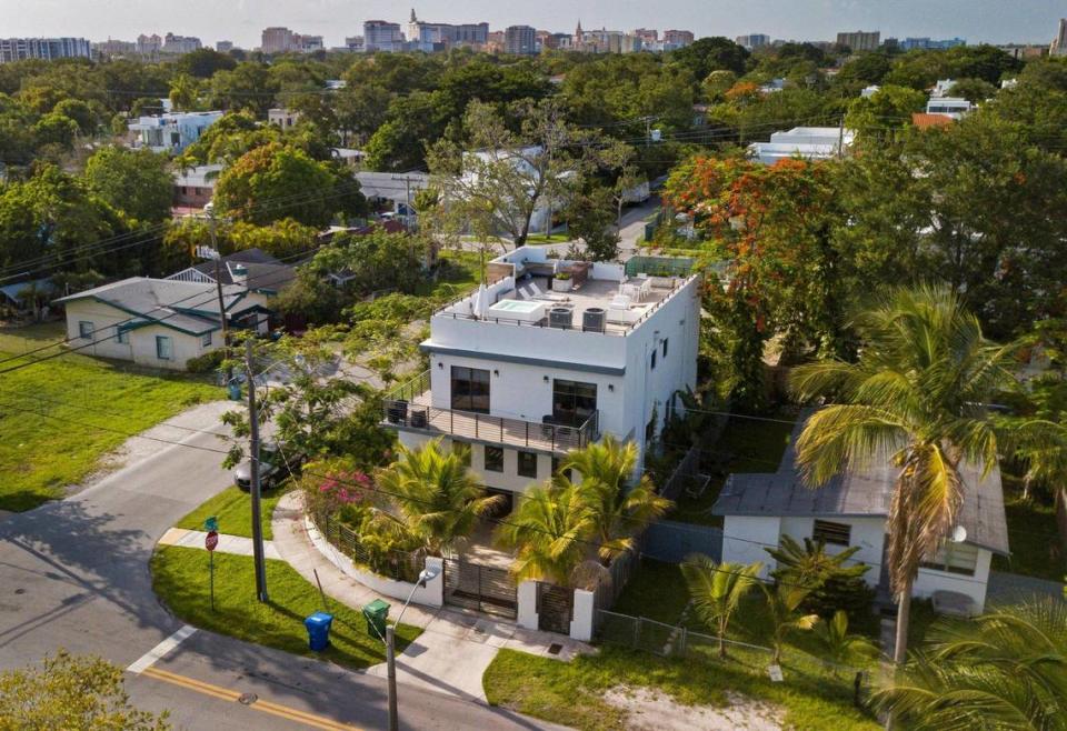 Una casa de lujo con una terraza en la azotea se asoma por encima de modestas casas de clase trabajadora en la esquina de Elizabeth Street y Frow Avenue, en el históricamente afroamericana West Coconut Grove, en Miami, el jueves 16 de junio de 2022. La comunidad afroamericana está desapareciendo en medio del rápido aburguesamiento.