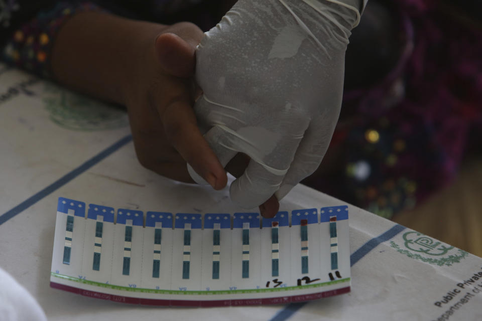 A Pakistani doctor takes blood sample of a villager to screen for HIV at a hospital in a village near Ratodero, a small town in southern province of Sindh in Pakistan where the outbreak of deadly disease took place last month, Thursday, May 16, 2019. Officials say about 500 people, mostly children, have tested positive for HIV, the virus that causes AIDS, in a southern Pakistani provincial district. A local doctor who has AIDS has since been arrested and is being investigated for possibly intentionally infecting patients. (AP Photo/Fareed Khan)