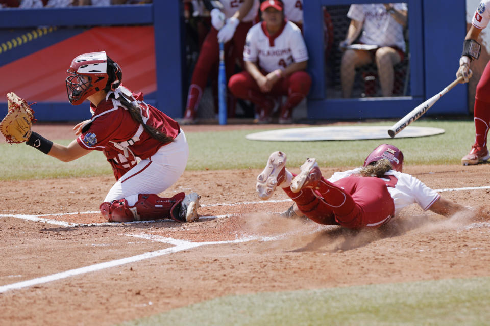 Oklahoma's Alyssa Brito, right, slides home to score past Stanford catcher Aly Kaneshiro during the second inning of an NCAA softball Women's College World Series game Monday, June 5, 2023, in Oklahoma City. (AP Photo/Nate Billings)