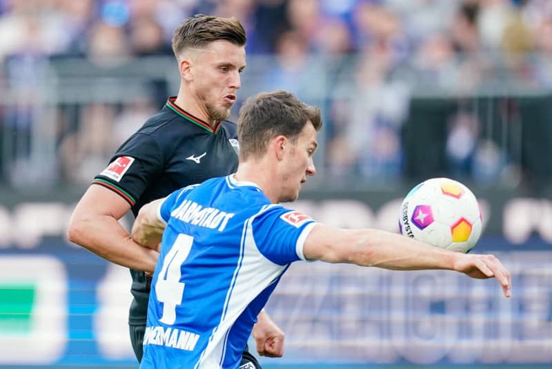 Augsburg's Ermedin Demirovic (L) and Darmstadt's Christoph Zimmermann fight for the ball during the German Bundesliga soccer match between SV Darmstadt 98 and FC Augsburg at Merck-Stadion am Boellenfalltor. Uwe Anspach/dpa