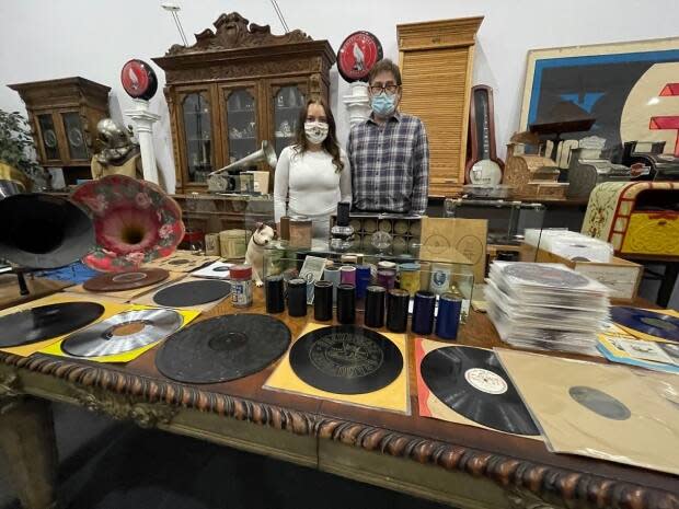 Jeff Kiss [right} and his daughter Kennedy Kiss stand behind of some of the family's collection of vintage vinyl records in a commercial bay in Leduc, Alta. (Travis McEwan/CBC - image credit)