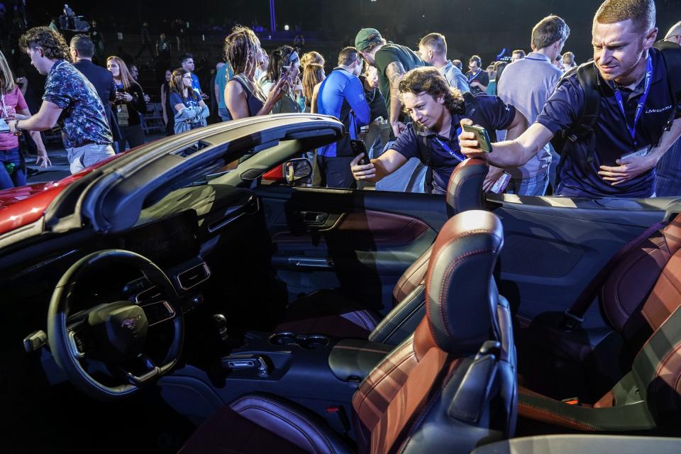 People crowd around different models of the 2024 Ford Mustang after it debuts during the 2022 North American International Auto Show held at Hart Plaza in downtown Detroit on Wed., Sept. 14, 2022.