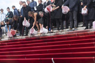 Activists of the group 'Extinction Rebellion' shedding red liquid, symbolizing blood, on the stairs of the recently opened promenade at the Baumwall during the Cruise Days in Hamburg, Germany, Saturday, Sept. 14, 2019. Extinction Rebellion held a protest march on the grounds of the Cruise Days to demonstrate for a better climate policy. (Jonas Walzberg/dpa via AP)