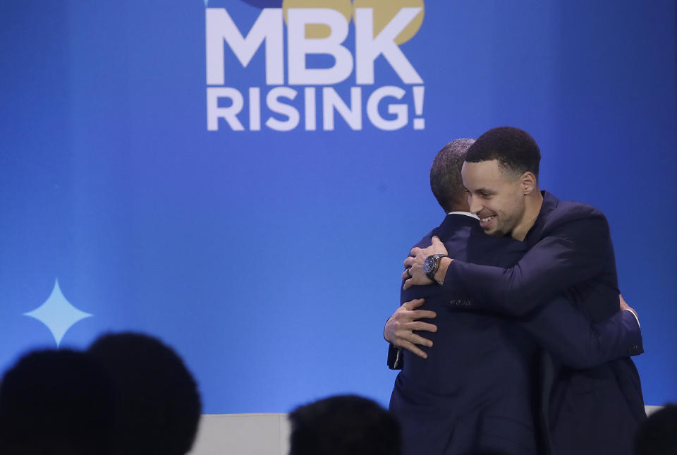 Former President Barack Obama, left, hugs Golden State Warriors basketball player Stephen Curry after speaking at the My Brother's Keeper Alliance Summit in Oakland, Calif., Tuesday, Feb. 19, 2019. (AP Photo/Jeff Chiu)