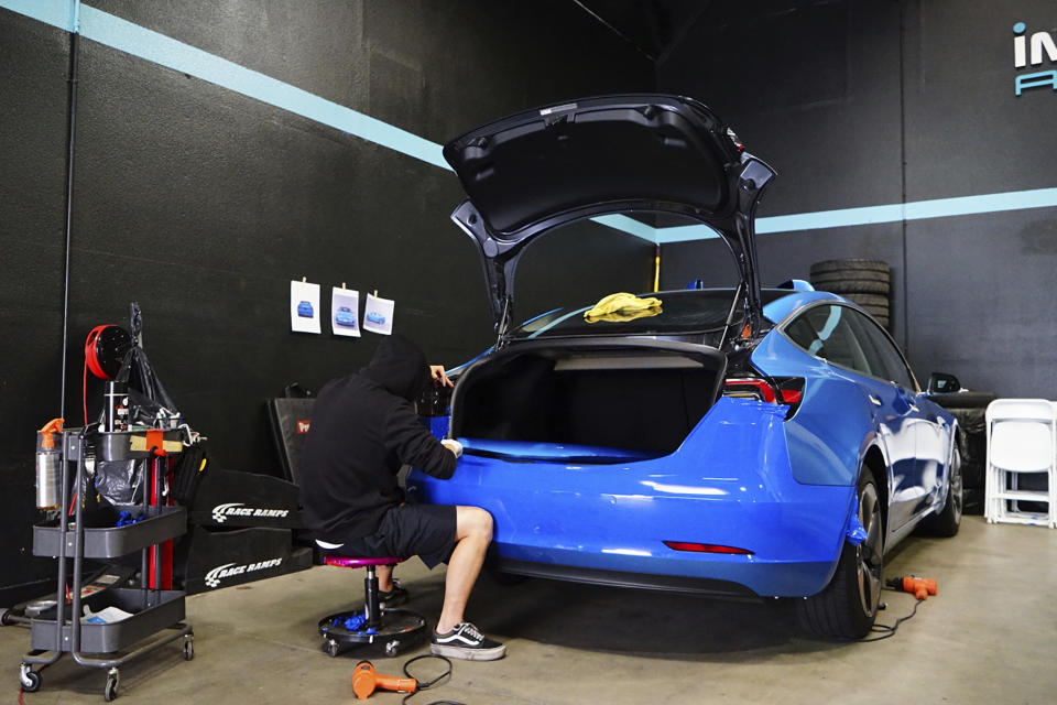 This photo provided by Edmunds shows a 2017 Model 3 during its professional wrap installation process. Just about any kind of color or graphic can be applied. (Courtesy of Edmunds via AP)