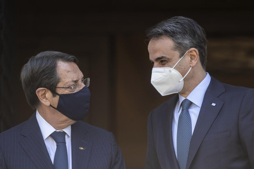 Greece's Prime Minister Kyriakos Mitsotakis, right, welcomes Cypriot President Nicos Anastasiades before their meeting at Maximos Mansion in Athens, Wednesday, April 21, 2021. (AP Photo/Petros Giannakouris)