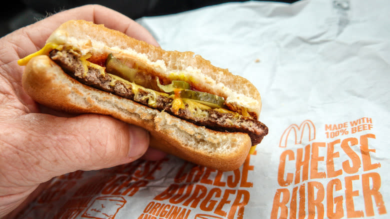 Hand holding McDonald's Cheeseburger