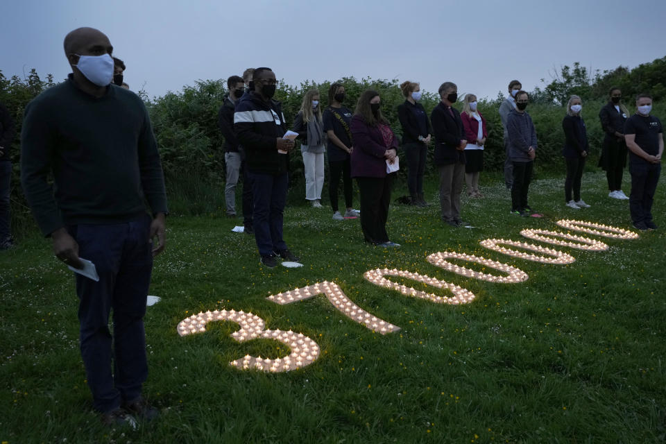 Campaigners attend a vigil to remember the millions who have died during the COVID-19 pandemic, organised by 'Crack the Crisis Coalition' in Falmouth, Cornwall, England, Friday, June 11, 2021. Leaders of the G7 began their first of three days of meetings on Friday in Carbis Bay, in which they will discuss COVID-19, climate, foreign policy and the economy. (AP Photo/Kirsty Wigglesworth)