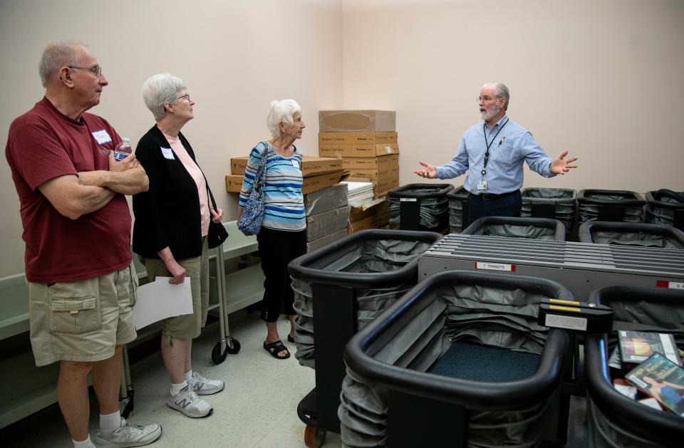 Nick Lonneman shows the library's sorting system to a tour group from the Friends of the Cape Coral Library. This sorter, which was provided by the Friends of the Cape Coral Library, sorts books from the 24-hour drop on the outside of the building.