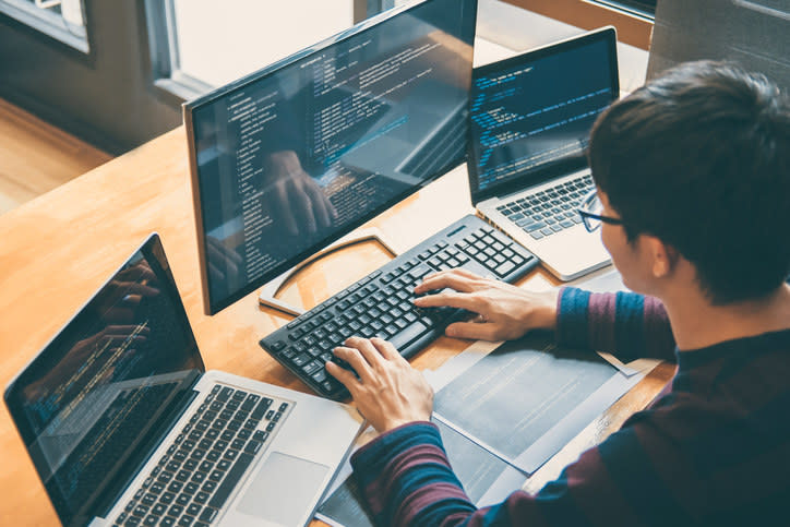 A man working on multiple computers