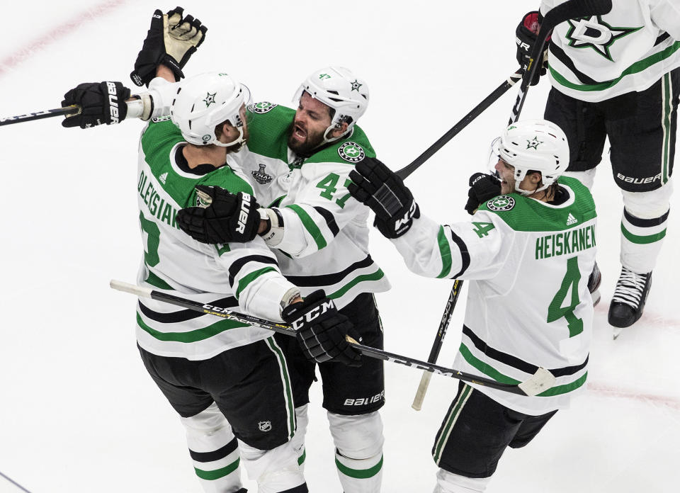 Dallas Stars' Jamie Oleksiak (2) celebrates his goal against the Tampa Bay Lightning with teammates Alexander Radulov (47) and Miro Heiskanen (4) during second-period NHL Stanley Cup finals hockey action in Edmonton, Alberta, Saturday, Sept. 19, 2020. (Jason Franson/The Canadian Press via AP)