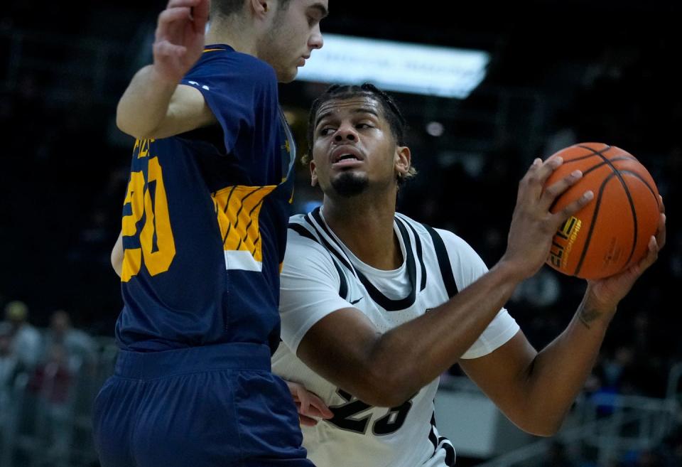 Providence Friar forward, BryceHopkins looks for a pass around Warrior defender Nick Filchner.  