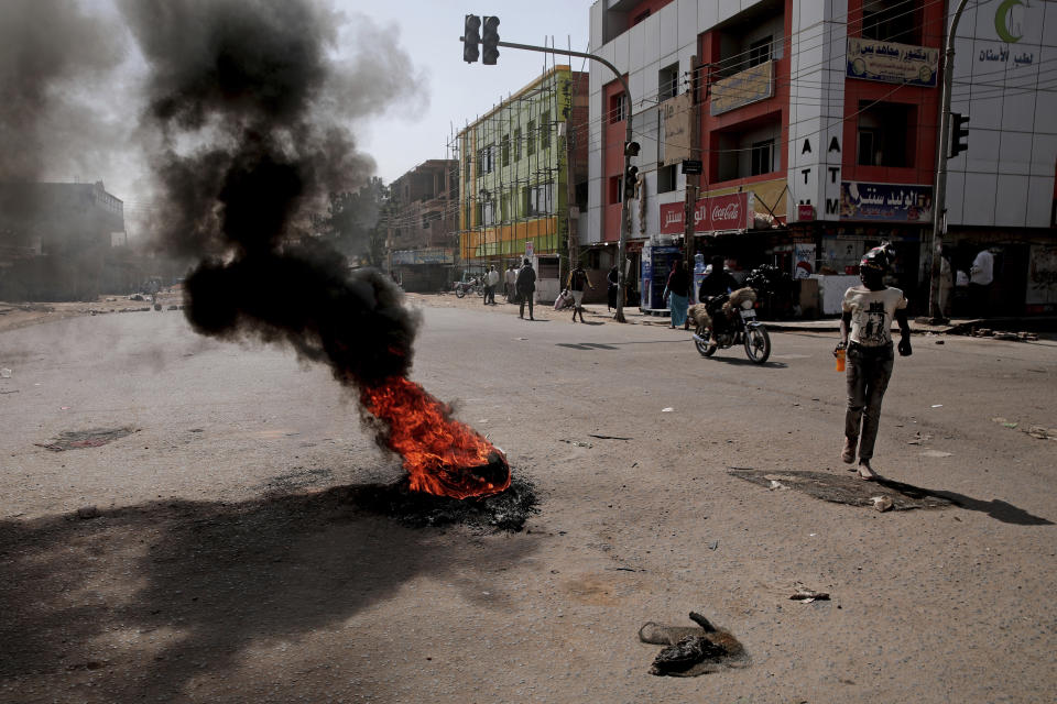 People set up a barricades and burn tires as part of a civil disobedience campaign following the killing of 7 anti-coup demonstrators in Khartoum, Sudan, Tuesday, Jan.18, 2022. The pro-democracy movement condemned Monday's deadly shootings and called for a two-day civil disobedience campaign over the security forces' actions. (AP Photo)