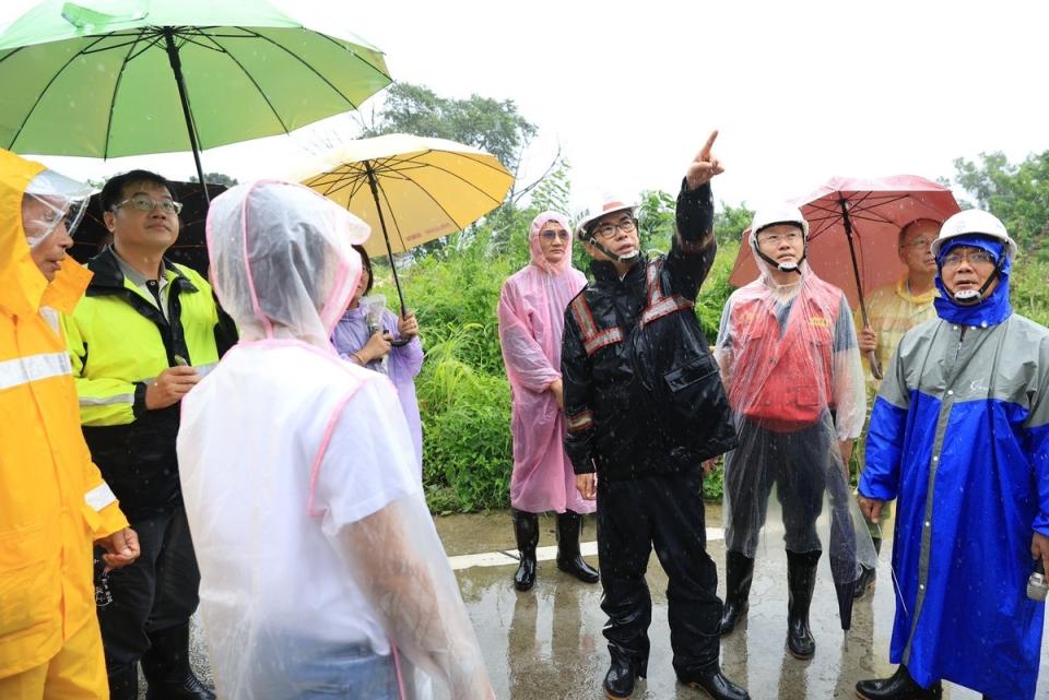 陳其邁(中)冒雨視察寶來一號橋邊邊坡崩塌情形。   圖：高雄市水利局提供